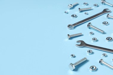 Tap cıvatalar, krom fındıklar ve mavi arka planda anahtarlar