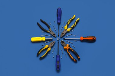 Mavi arka planda pense, tornavida ve vidalar