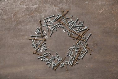 Gri grunge arka planında farklı vidalar ve krom fındıklar