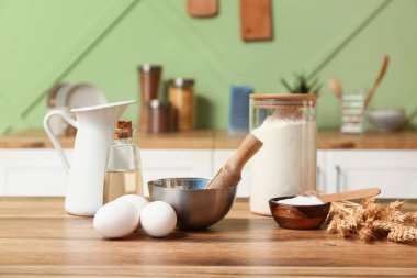 Taze yumurta, un, kabartma tozu ve yağ mutfak masasında.