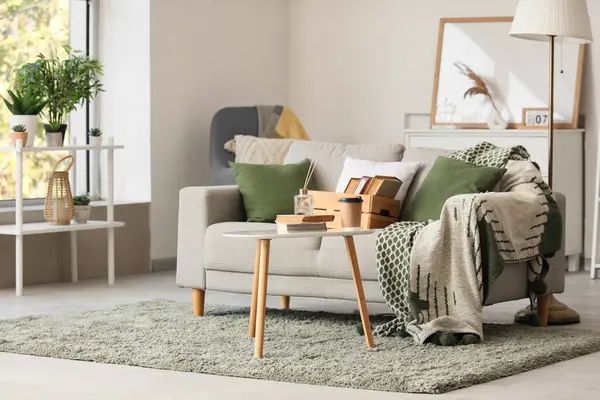 Oturma odasının içinde kitaplar olan rahat bir kanepe ve kahve masası.