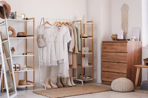 Giysi askısı, raf ünitesi ve çekmeceleri olan soyunma odasının içinde.