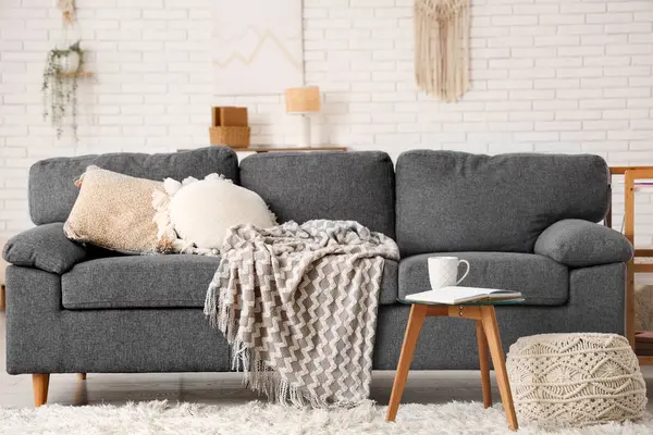 Oturma odasındaki sehpanın üzerinde açık bir kitap ve çay.