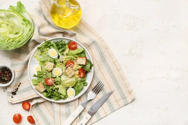 Lezzetli Sezar salatası, yağ ve beyaz arka planda bir kase biber.