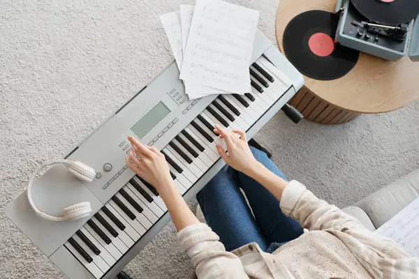 Evde sentezleyici çalan kadın, üst görünüm