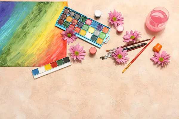 Bej grunge arka planda sanatçı fırçaları, boyalar ve çiçekler