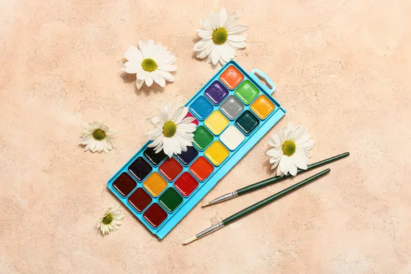Bej grunge arka planda sanatçı fırçaları, boyalar ve çiçekler