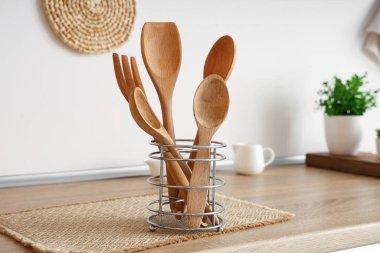 Mutfaktaki masada ahşap çatal bıçaklı tutucu, yakın plan.