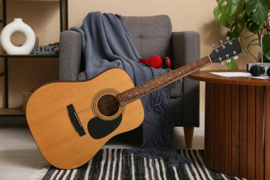 Modern akustik gitar şık bir oturma odasında yerde.