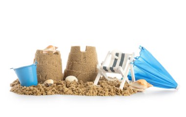 Kumdan, deniz kabuklarından, küçük şemsiyelerden, beyaz arka planda iskemle ve kovadan yapılmış bir kale.