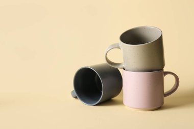 Renk arkaplanında farklı seramik bardaklar