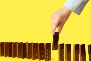 Kadın sarı arka planda domino taşından iniyor