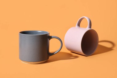 Turuncu arkaplanda seramik bardaklar