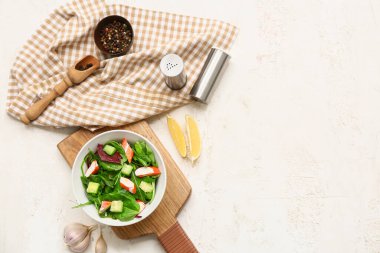 Beyaz grunge arka planda bir kase salata, ıspanak ve salatalık.