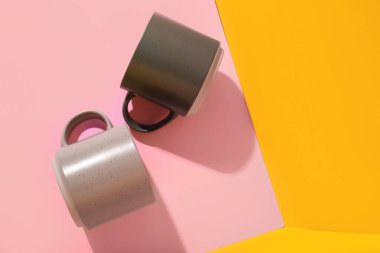 Renk arkaplanında farklı seramik bardaklar