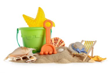 Plaj oyuncakları, mini sandalye ve beyaz arka planda kum.