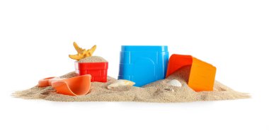 Plaj oyuncakları ve beyaz arka planda kum