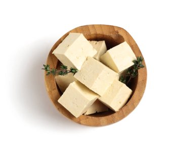 Beyaz arka planda kesilmiş soya peynirli ahşap kase.