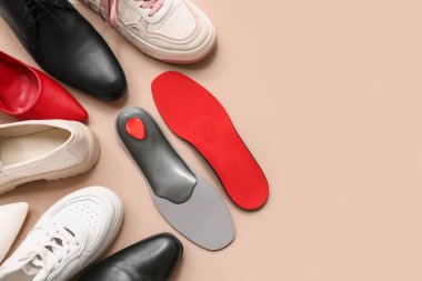 Bej arkaplanda ortopedik tabanlı farklı ayakkabılar ve metin için boşluk