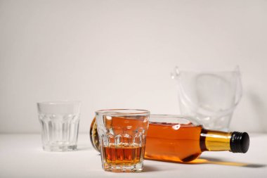 Beyaz arka planda bardak ve bir şişe rom.