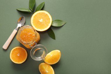 Yeşil arka planda bir kavanoz lezzetli portakal reçeli