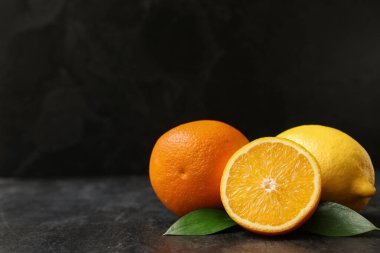 Taze olgun portakallar ve siyah arka planda limon.