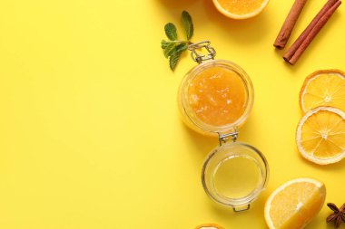 Sarı arka planda lezzetli turuncu reçel kavanozu