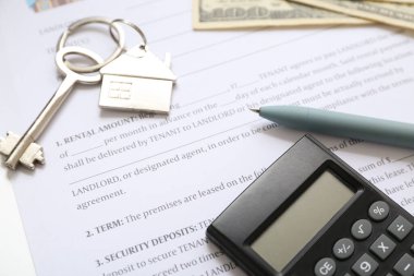 Ev kiralama anlaşmasında hesap makinesi ile anahtar, yakın plan