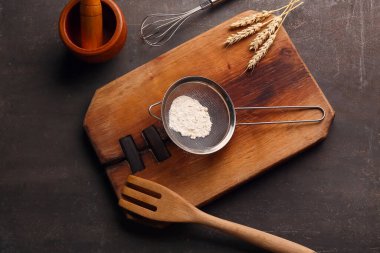 Un, mutfak gereçleri ve arka planda çivili metal elek.