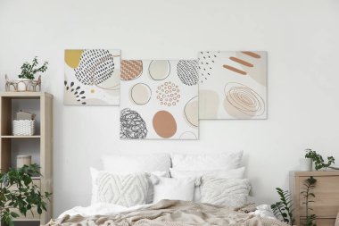 Şık yatak odaları, rahat yataklar, ev bitkileri ve güzel tablolar.