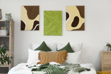 Şık yatak odaları, rahat yataklar, ev bitkileri ve güzel tablolar.