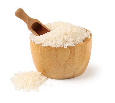 Tahta kase ve kepçeyle beyaz arka planda çiğ pirinç.