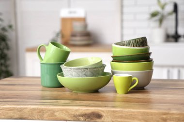 Mutfaktaki ahşap masada çanaklar ve fincanlar.