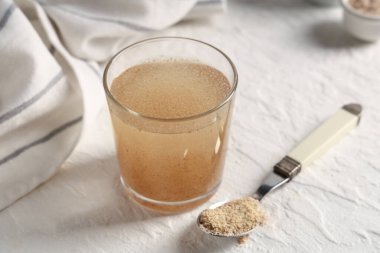 Beyaz grunge arka planda psyllium kabuklu bir bardak su.