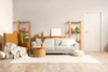 Rahat kahverengi koltuğu, gri kanepesi ve ahşap sehpası olan şık bir oturma odası.