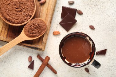 Bir fincan kakao tozu ve beyaz grunge arka planda fasulye.