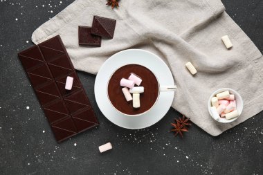 Bir fincan kremalı sıcak çikolata ve siyah grunge arka planda yıldız anason.