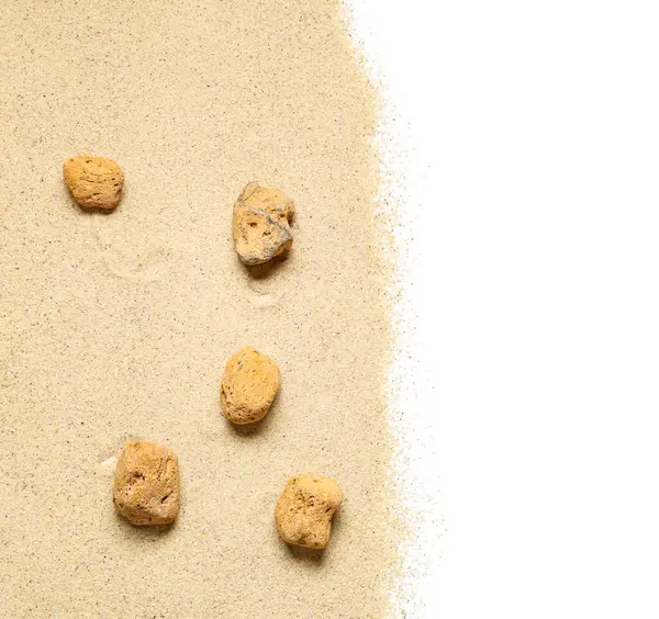 Beyaz zemin üzerinde taşlar olan hafif kumsal kumu