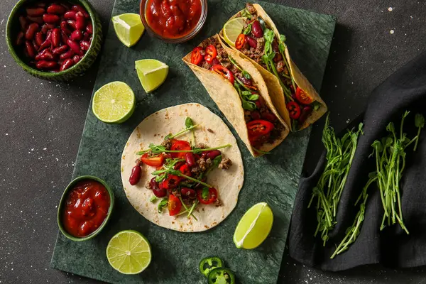 Taze takolu tepsi ve siyah benekli arka plandaki malzemeler.