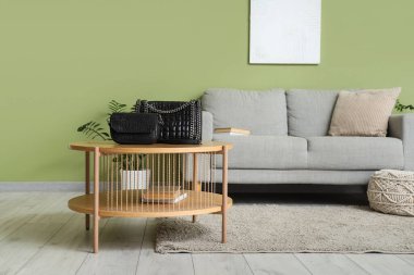 Oturma odasının içindeki masada şık çantalar var.