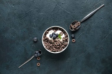 Mısır gevreği halkalı kase ve mavi grunge arka planda süt