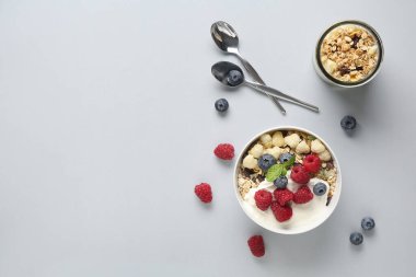 Beyaz arka planda sağlıklı mısır gevreği, yoğurt ve böğürtlen kâsesi.