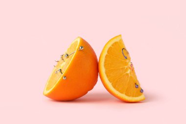 Pembe arka planı delinmiş portakal meyveleri.