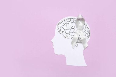 Beyni ve mor arka planda gri farkındalık kurdelesi olan kağıt insan kafası. Kanser kavramı