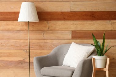 Gri koltuklu, standart lambalı ve çiçekli şık bir oturma odası.