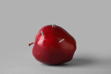 Gri arkaplanda piercing olan elma