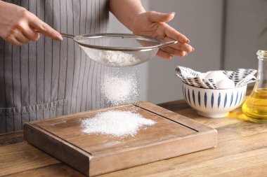 Mutfaktaki masada un elleyen bir kadın.