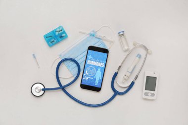 Glukometresi, steteskobu ve ışık arka planında insülin olan cep telefonu. Endokrinoloji kavramı