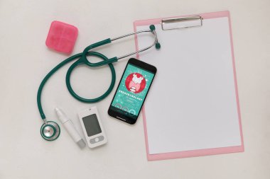 Glukometresi, steteskopu ve arka planda boş bir panosu olan cep telefonu. Endokrinoloji kavramı