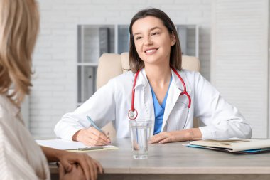 Klinikte bir hastayla çalışan kadın doktor.